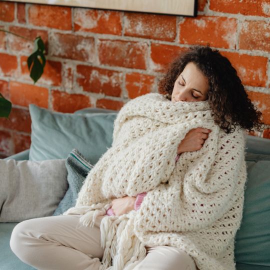 woman snuggling blanket